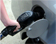 Close-up of hand holding gasoline pump nozzle in a carâ€™s gas tank